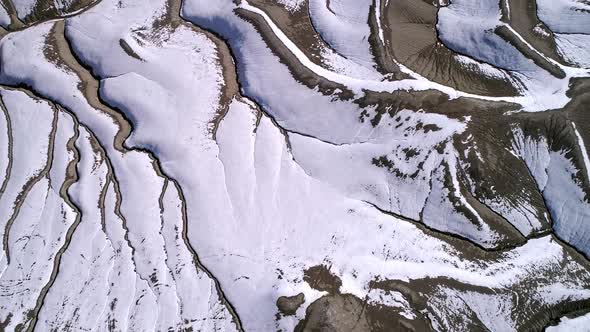Aerial view looking down at desert eroded terrain in winter alt