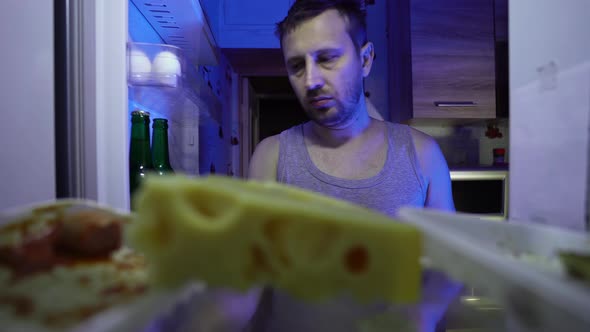 Unemployed looking for food in the fridge at night. Financial crisis alt