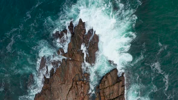 Ocean Waves Crash Against Stony Rocks During Sunset on the Island of Sri Lanka
