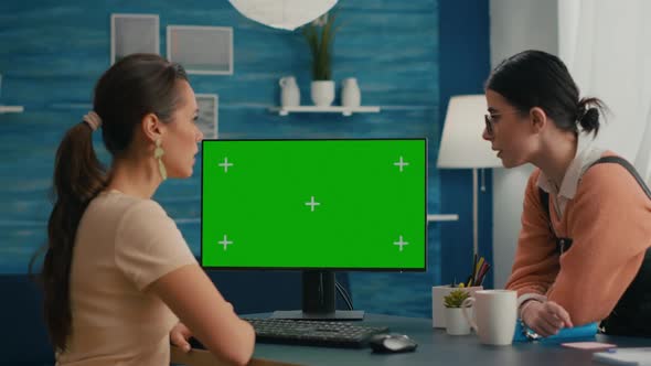 Two Friends Sitting in Front of Mock Up Computer Green Screen alt