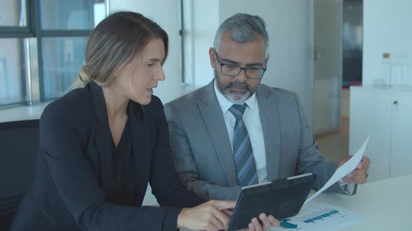 Focused Business Leaders Analyzing Reports alt