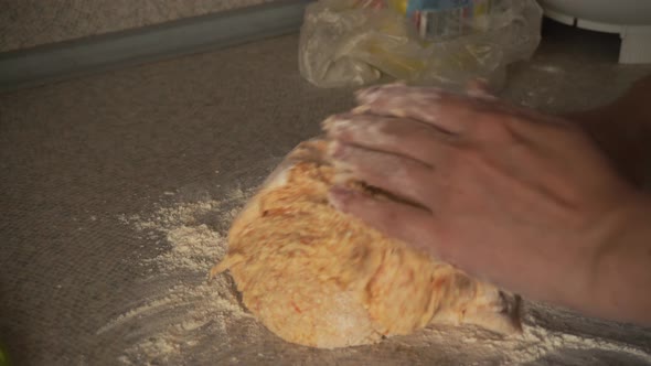 Female Hands Gently Knead the Dough with Pumpkin