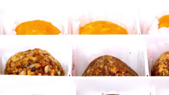 Delicious Sweets of Different Tastes Lie in White Paper Box alt