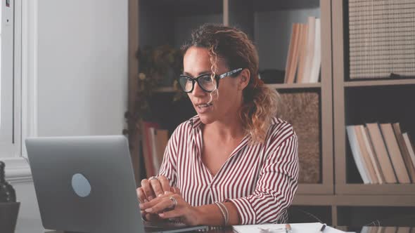 Overjoyed caucasian ethnicity girl sit at desk looks at laptop screen read incredible news