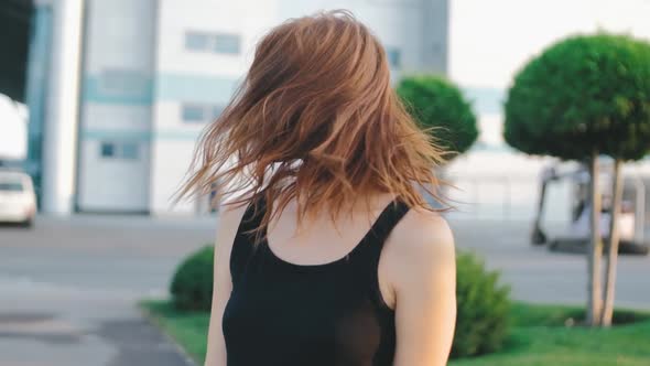 Beautiful Redhaired Woman with Long Hair on Street at Sunset alt