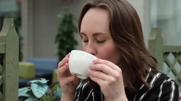 Young Girl Enjoys Drinking Tea alt