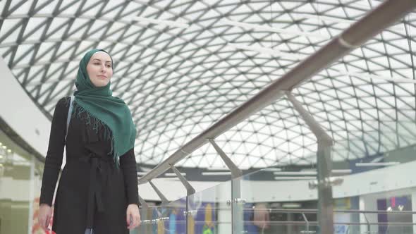 Pretty Muslim Woman in a Hijab with a Backpack Goes To the Storeslow Mo alt