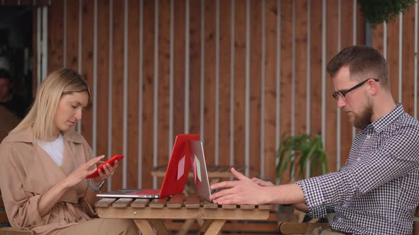 Two Male and Female Visitors of Street Cafe Are Working with Laptops alt