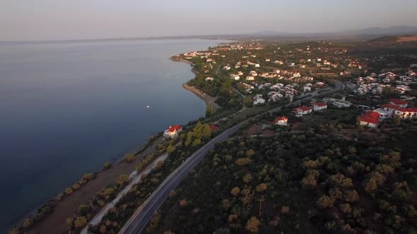 Flying Over Trikorfo Beach Coastline with Cottages and Green Uplands, Greece alt