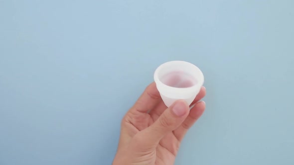 A Woman Holds a Menstrual Cup in Her Hands alt