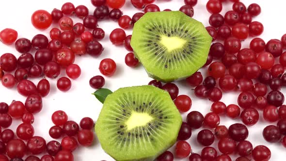 Kiwi and cranberries are on a white background