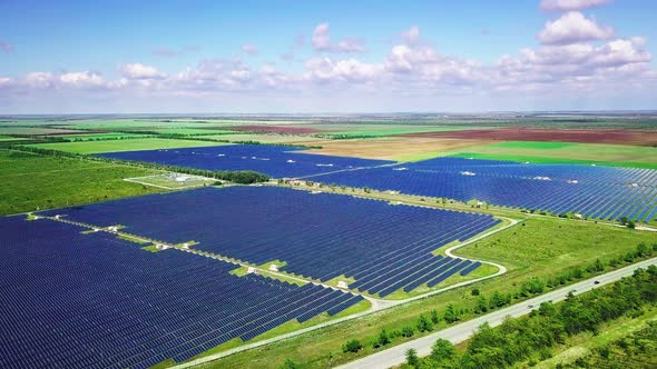 Photovoltaic Solar Panels on Green Field at Sunny Day. Aerial Landscape alt
