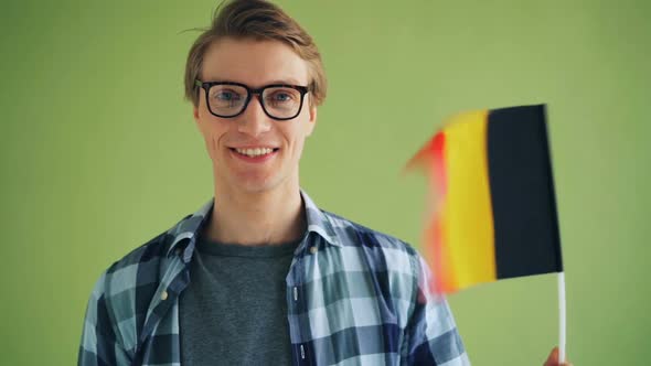 Slow Motion of Male Student Patriot Holding Flag of Germany and Smiling alt