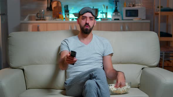 Adult Man Eating Popcorn While Standing in Front of Television alt