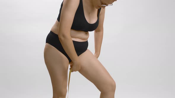 Plus Size Young Caucasian Woman Measuring Her Leg