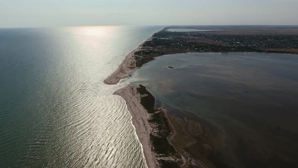 Aerial Shot of Upright Sandspit Touching a Curvy Stripe at Sunset in Summer