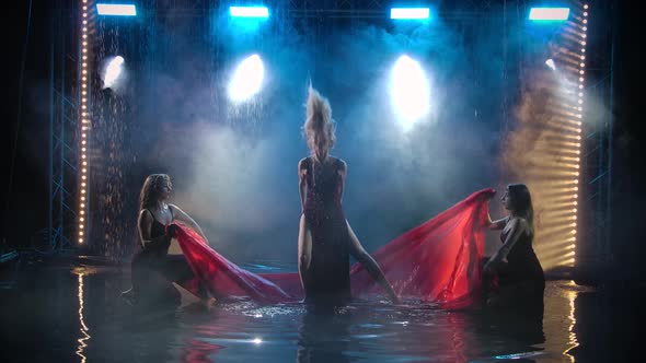 The Dance Group of Women Gracefully Dance with a Silk Red Cloth Among the Raindrops alt