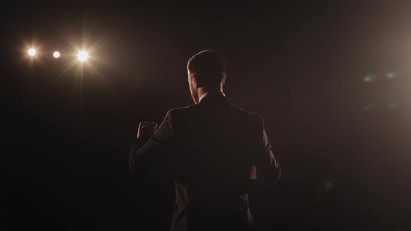 A Man is Standing on the Stage and Talking alt