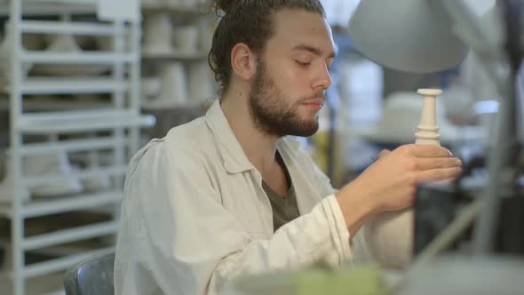 Male artist carving crafts product in workshop