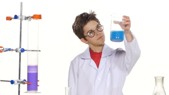 Young Boy Chemist Wearing Uniform, Red Shirt and Round Glasses in Laboratory Making Some Experiment alt