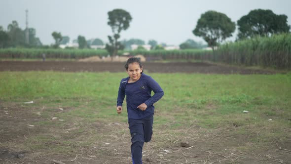 Slowmotion Shot of an Indian Boy Running in Agricultural Field of India