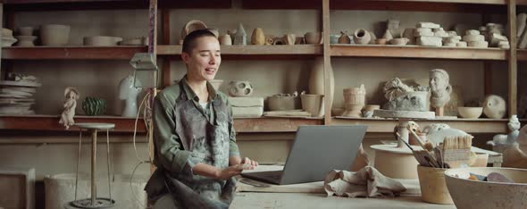 Female Potter Video Calling on Laptop in Workshop alt