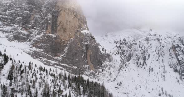 Backward Aerial with Snowy Mountain and Woods Forest at Sella Pass