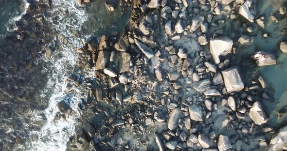 Aerial footage of the the beautifu rocks and sunny beach of Armação in Florianópolis, Brazil. alt