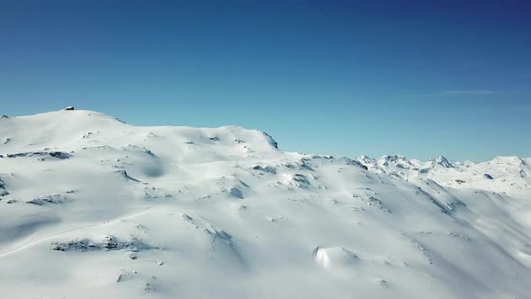 Aerial drone view of snow covered mountains in the winter. alt