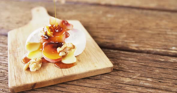 Cheese topped with walnut, fruits and sauce alt