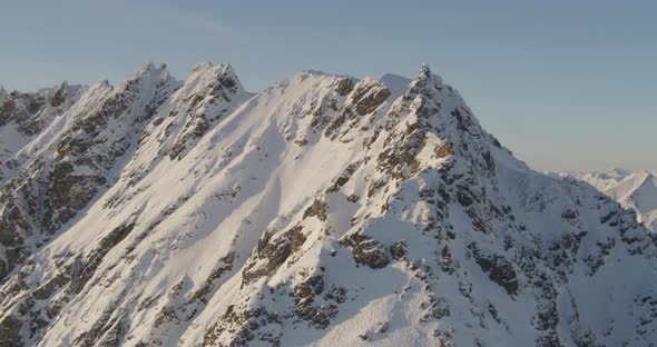 Aerial helicopter shot, steam rising from power plant, cars pass on highway, snow in background