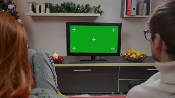 Authentic Couple over Sholder close up Shot Watches Green Screen TV Mockup Sitting on Couch alt