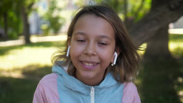 Portrait of Kid Outdoor. Portrait of Cute Child Outdoor with Headphones, Cute Girl Smiling alt
