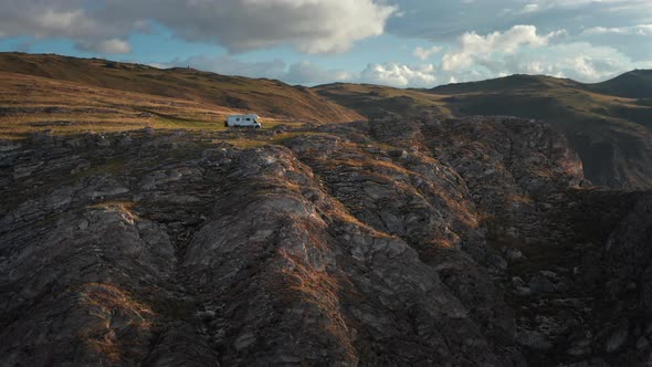RV Camper Van on Mountains Landscape Near High Cliff Aerial Shot