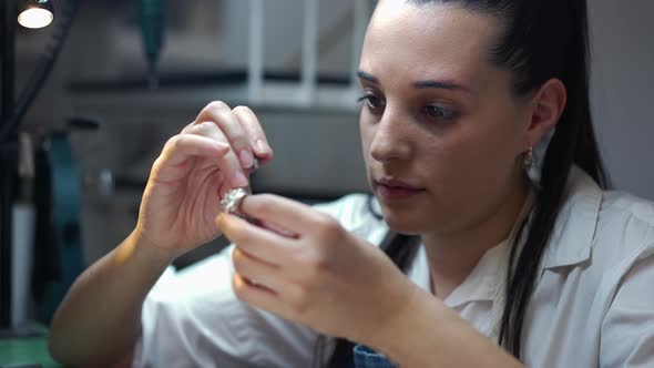 Young Focused Female Jeweller Engraving Gemstones in Ring in Slow Motion alt