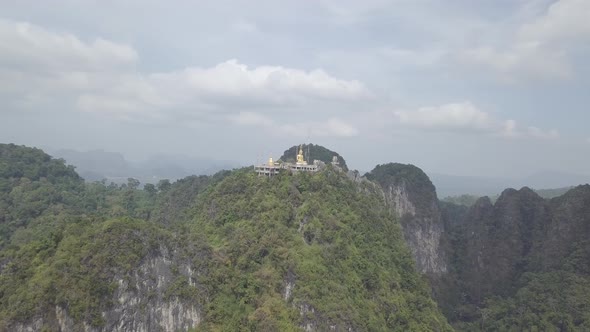 Aerial footage of Buddha on top of Tiger Cave Temple, Wat Thum Sua, stone rocks, Krabi, Thailand alt
