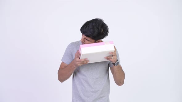Young Handsome Bearded Indian Man Thinking While Holding Gift Box alt