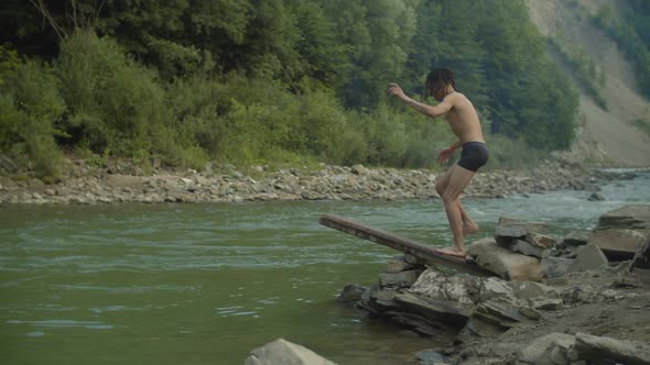 Cheerful Man Diving Into Mountain River Off Wooden Springboard alt