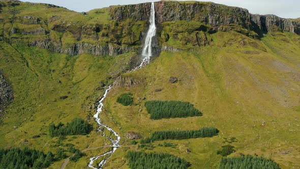 Aerial Drone Footage of Bjarnarfoss Waterfall with Its Green Cliffs in Western Iceland alt