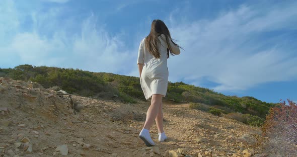 Pretty Young Woman Tourist Walking in the Desert Mountains Near Sea alt