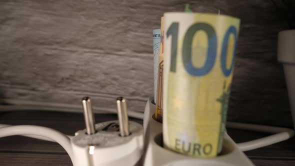 Closeup Shot of Money and a Socket Showing the High Energy Price Concept alt