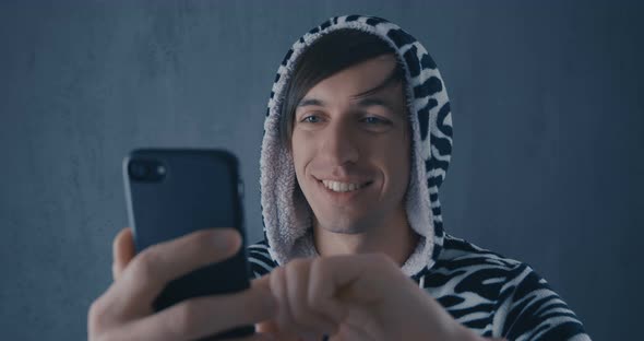 Portrait of Young Man in Costume Zebras Using Smartphone