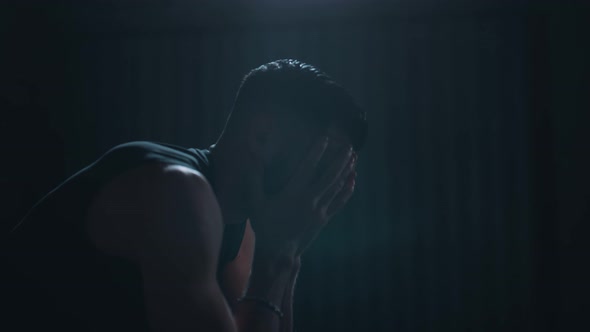 Man alone in a dark room alt