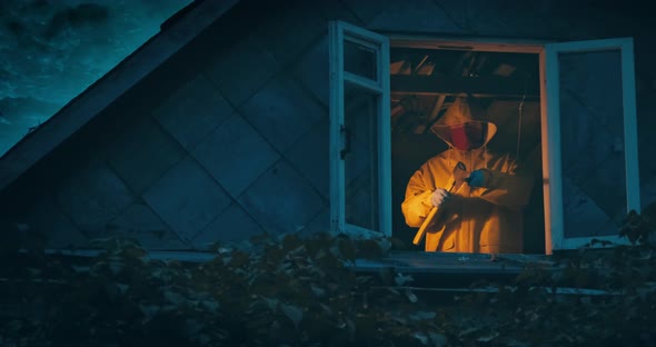 Maniac in Yellow Raincoat with an Axe and a Knife on Top Floor of an Old House alt