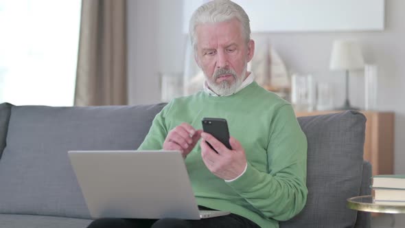 Old Man with Laptop Talking on Smartphone alt