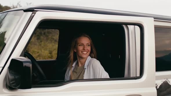 Young Woman Coming Out of Offroad Car in the Countryside