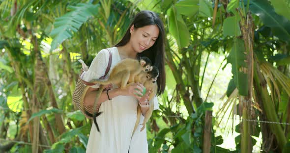 Woman tourist go to the park for visit  Squirrel Monkey alt