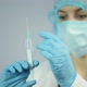 Tired nurse on duty wearing face mask preparing injection in syringe for patient - VideoHive Item for Sale