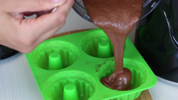 A Woman Pours A Banana Chocolate Smoothie Into A Silicone Mold. From The Blender. Shot Close Up.