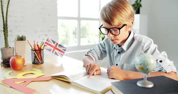 Male Pupil Reading English Book